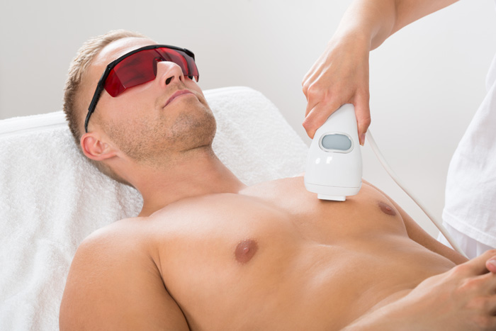 A man is receiving laser hair removal on the chest