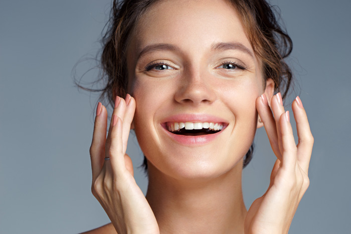 A woman admires her wrinkle-free smile after Botox at one of our UK clinics